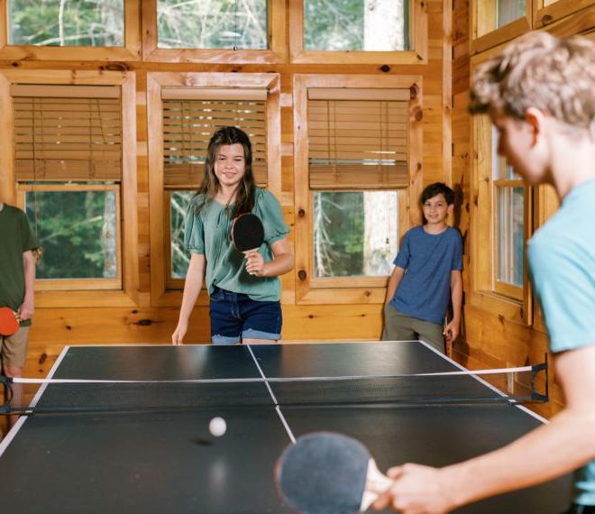 children playing ping pong in a cabin