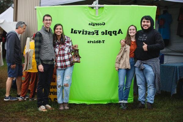 guests standing in front of Apple Festival t-shirts display