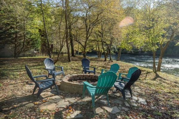 a fire pit surrounded by chairs in the fall